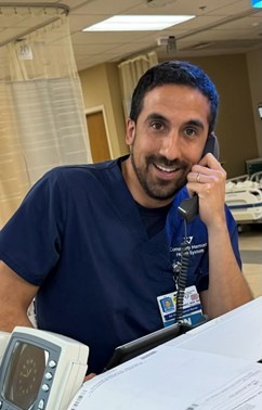 Male staff member smiling on phone at Ventura College Foundation event.