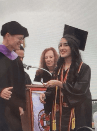 Ventura College graduate receiving diploma during commencement ceremony.