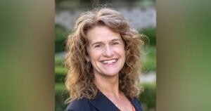 Portrait of a smiling woman with curly hair, outdoors, representing Ventura College Foundation.