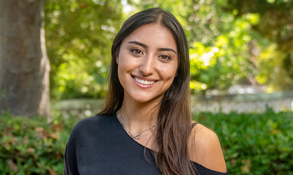 Happy female student outdoors at Ventura College, smiling confidently.