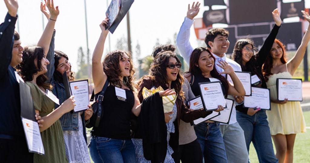 Students celebrating and holding certificates at Ventura College Foundation event.